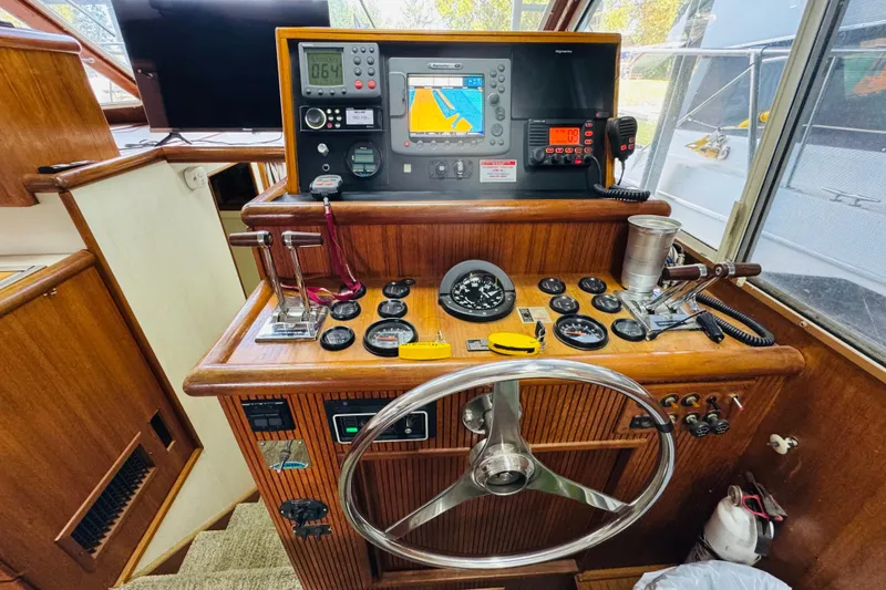 Slide: The Image of 1987 Tollycraft 40 Sport Sedan helm with navigation instruments and wooden dashboard. - 34