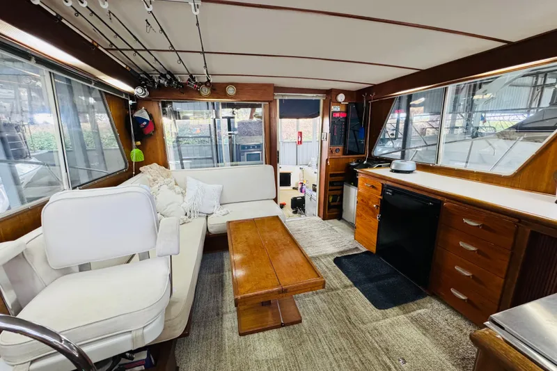 Slide: The Image of Interior of 1987 Tollycraft 40 Sport Sedan with seating, fishing rods, and kitchenette. - 37