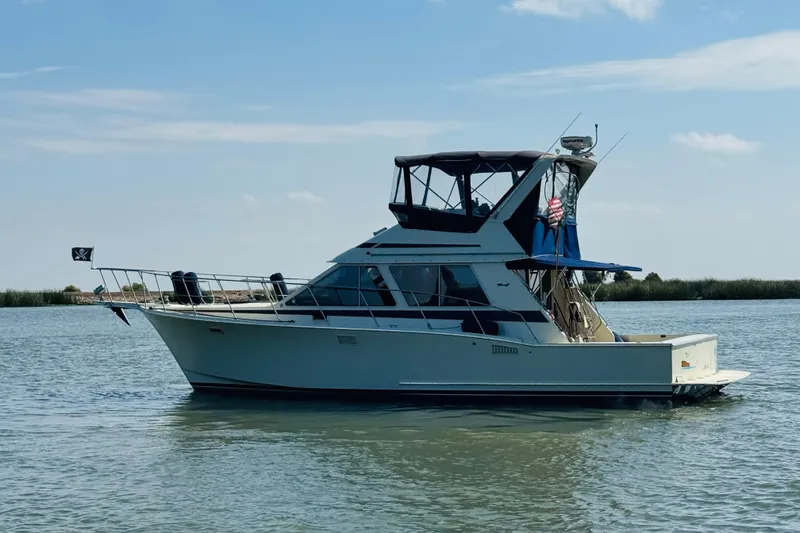 Slide: The Image of 1987 Tollycraft 40 Sport Sedan yacht on calm water under blue sky. - 4