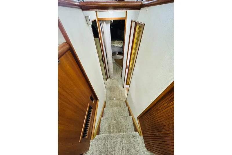Slide: The Image of Interior hallway of 1987 Tollycraft 40 Sport Sedan with carpeted stairs and wooden accents. - 40