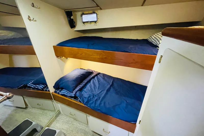 Slide: The Image of 1987 Tollycraft 40 Sport Sedan cabin with cozy bunk beds and blue bedding. - 43