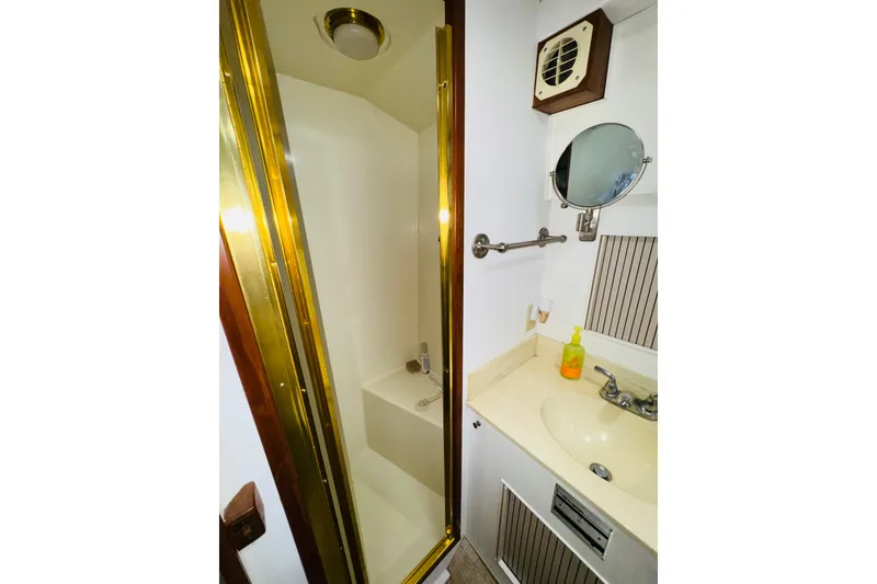 Slide: The Image of 1987 Tollycraft 40 Sport Sedan bathroom with shower, sink, and mirror. - 45