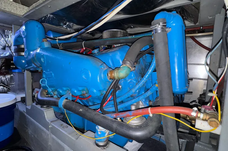Slide: The Image of Engine compartment of a 1987 Tollycraft 40 Sport Sedan, featuring a blue marine engine. - 55