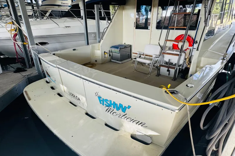 Slide: The Image of 1987 Tollycraft 40 Sport Sedan docked, featuring spacious deck and seating area. - 9