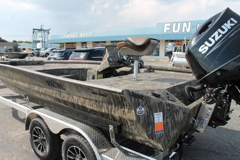 Slide: The Image of 2026 Excel Bolt 203 boat with Suzuki engine at dealership, featuring camouflage design. - 2