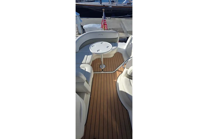 Slide: The Image of 2006 Sea Ray 260 Sundancer boat interior with seating and table, docked at marina. - 4