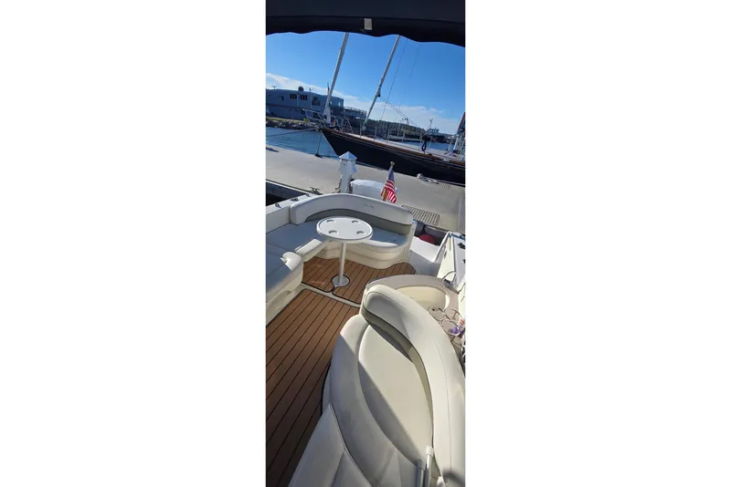 Slide: The Image of 2006 Sea Ray 260 Sundancer boat interior with seating and table, docked at marina. - 6