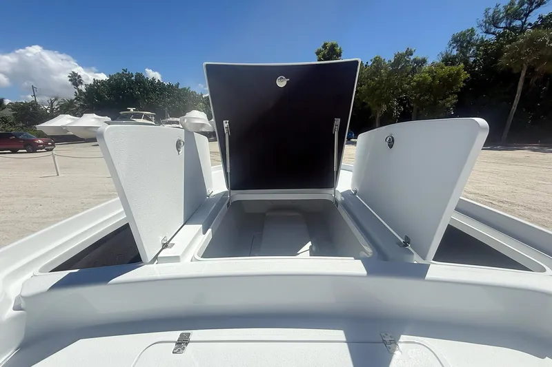 Slide: The Image of 2026 Yellowfin 24 Bay CE boat storage compartments open under clear sky. - 12