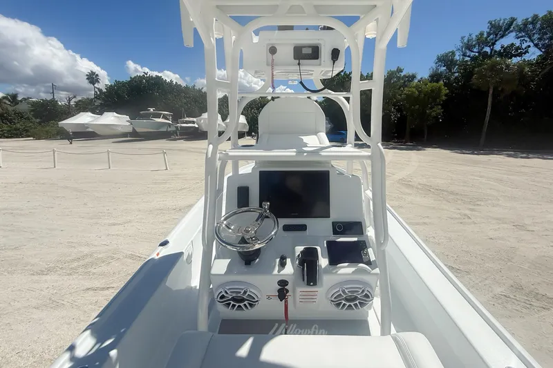 Slide: The Image of 2026 Yellowfin 24 Bay CE boat on trailer, parked under clear blue sky with palm trees. - 2