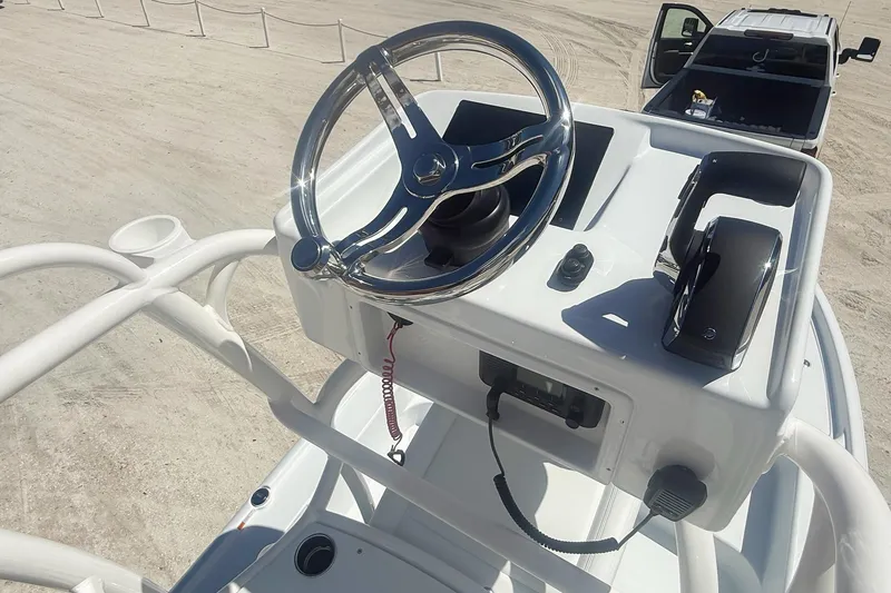 Slide: The Image of 2026 Yellowfin 24 Bay CE boat console with modern controls and speakers, docked under clear skies. - 5
