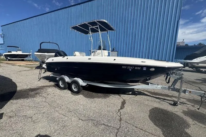 Slide: The Image of 2018 Bayliner Element F21 boat on trailer, parked outdoors near blue building. - 11