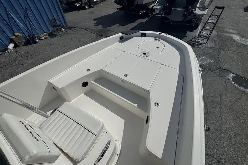 Slide: The Image of 2018 Bayliner Element F21 boat interior with white seating and storage compartments. - 13