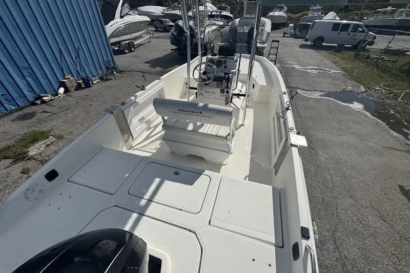 Slide: The Image of 2018 Bayliner Element F21 boat in a marina, showcasing its spacious deck and controls. - 8
