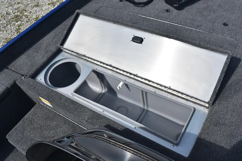 Slide: The Image of 2026 Lowe Skorpion 17 boat storage compartment open on gravel surface. - 14