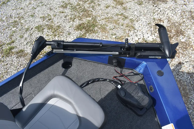 Slide: The Image of 2026 Lowe Skorpion 17 boat interior with steering wheel and seating on gravel surface. - 16