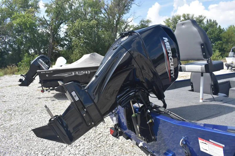 Slide: The Image of 2026 Lowe Skorpion 17 boat interior with steering wheel and seating on gravel surface. - 7