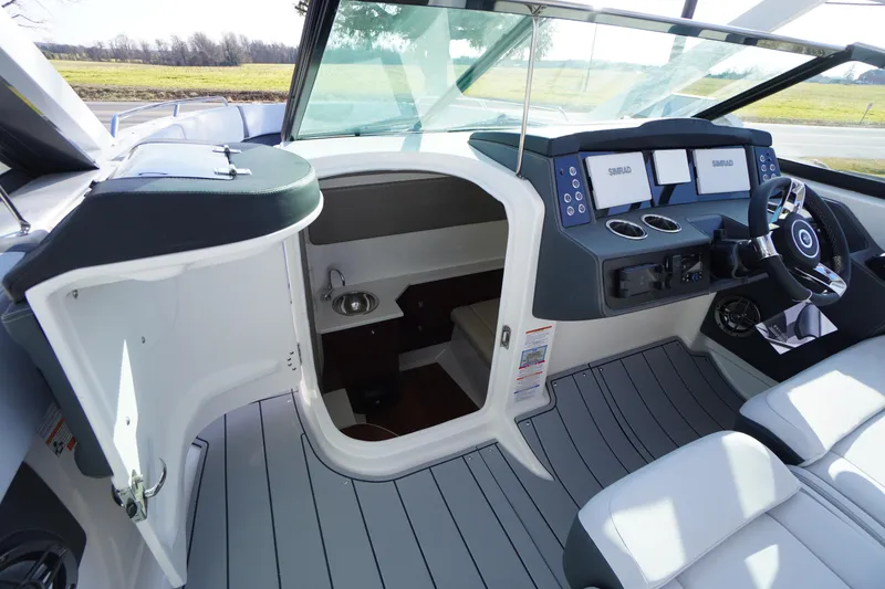 Slide: The Image of 2026 Chaparral 280 OSX boat interior with helm, seating, and cabin entrance. - 20