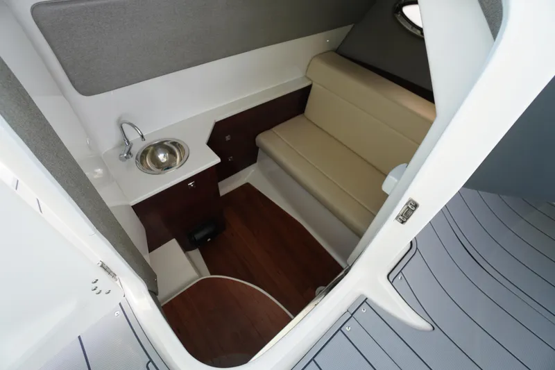 Slide: The Image of 2026 Chaparral 280 OSX cabin interior with sink, seating, and wood flooring. - 21