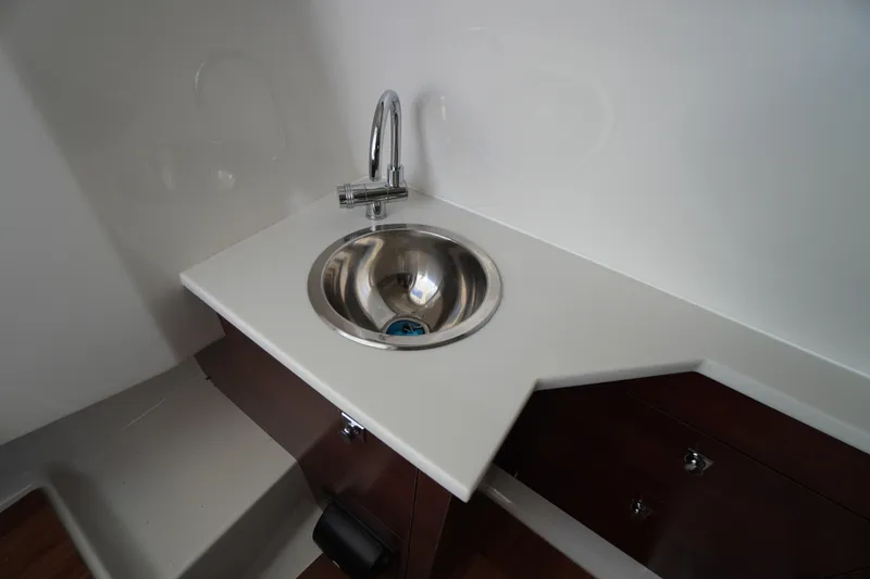 Slide: The Image of 2026 Chaparral 280 OSX boat interior sink with modern faucet and sleek countertop design. - 23