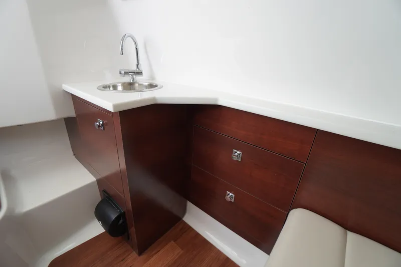 Slide: The Image of Luxurious interior of 2026 Chaparral 280 OSX boat with sink and wooden cabinetry. - 27