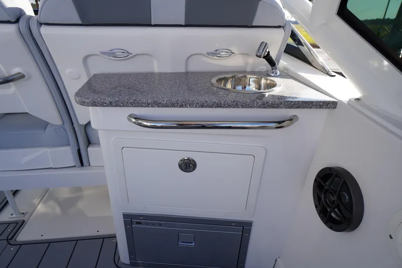 Slide: The Image of 2026 Chaparral 280 OSX boat interior with sink and storage area. - 33