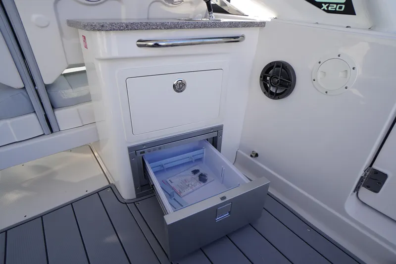 Slide: The Image of 2026 Chaparral 280 OSX boat interior with open storage drawer and sleek design. - 34