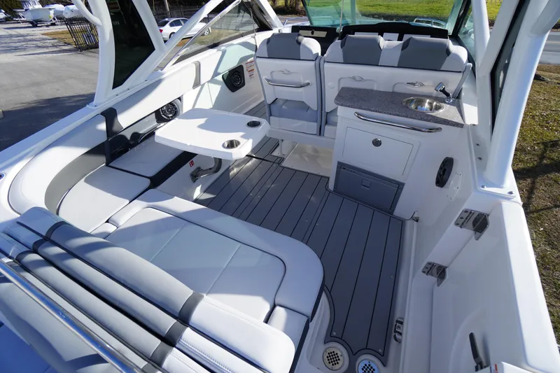 Slide: The Image of 2026 Chaparral 280 OSX boat interior with seating, table, and kitchenette. - 41