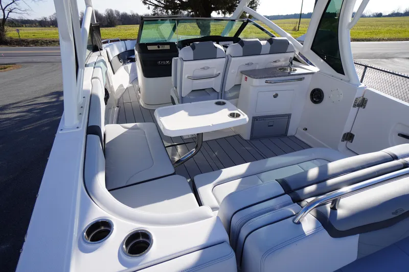 Slide: The Image of 2026 Chaparral 280 OSX boat interior with seating, table, and kitchenette. - 42
