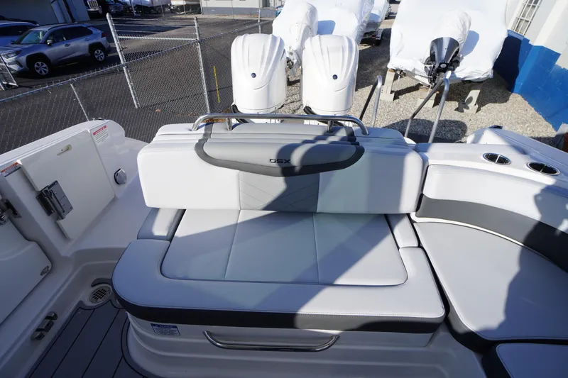 Slide: The Image of 2026 Chaparral 280 OSX boat interior with cushioned seating and dual outboard motors. - 44