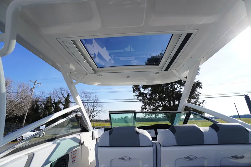 Slide: The Image of 2026 Chaparral 280 OSX boat interior with panoramic sunroof and sleek seating design. - 50