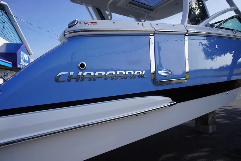 Slide: The Image of 2026 Chaparral 280 OSX boat side view with blue and white exterior. - 62