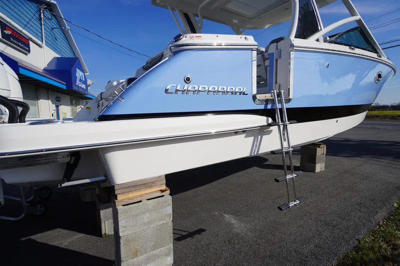 Slide: The Image of 2026 Chaparral 280 OSX boat on display with blue and white exterior. - 63
