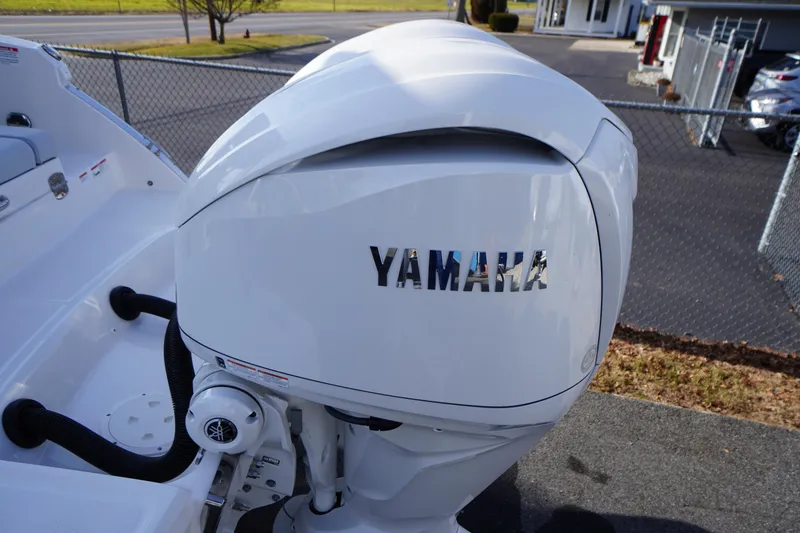 Slide: The Image of Yamaha outboard motor on 2026 Chaparral 280 OSX boat, parked near a fence. - 66