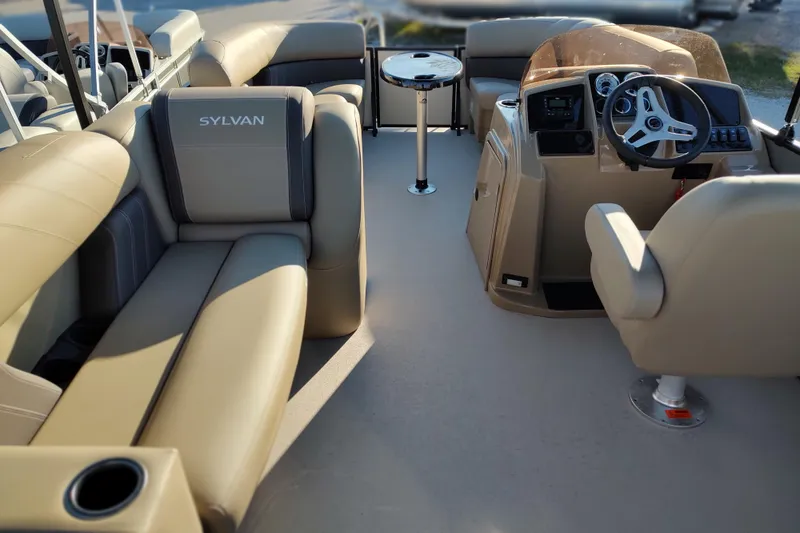 Slide: The Image of 2026 Sylvan Mirage 820 PARTY FISH boat interior with beige seating and steering console. - 1