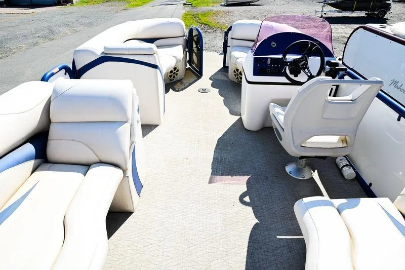 Slide: The Image of 2023 Aloha Pontoon boat interior with white seating and steering console. - 13