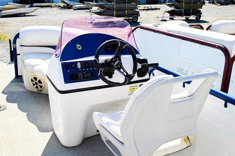 Slide: The Image of 2023 Aloha Pontoon boat interior with steering wheel and seating area. - 14