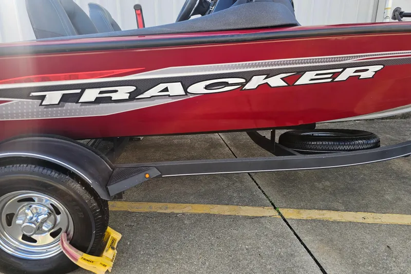 Slide: The Image of 2021 Tracker Pro Team 175 TXW boat, red with bold branding, on a trailer. - 4