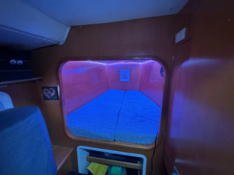 Slide: The Image of Cozy cabin interior of 2004 Lagoon 380 catamaran with blue ambient lighting. - 12