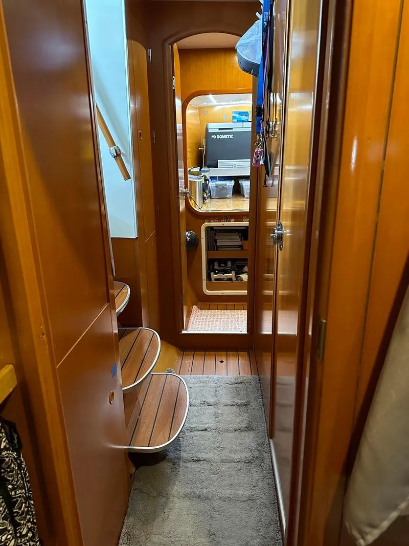 Slide: The Image of Interior view of 2004 Lagoon 380 catamaran, featuring wooden finishes and compact design. - 17