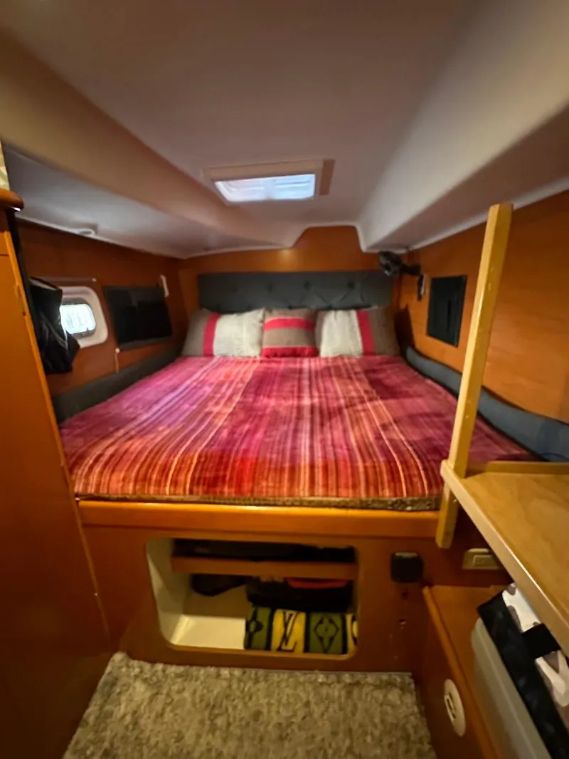Slide: The Image of Cozy cabin interior of 2004 Lagoon 380 catamaran with a comfortable bed and wooden accents. - 18