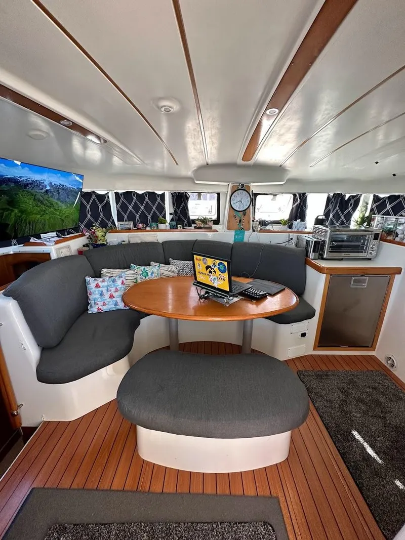 Slide: The Image of Interior of a 2004 Lagoon 380 catamaran with cozy seating and modern amenities. - 6