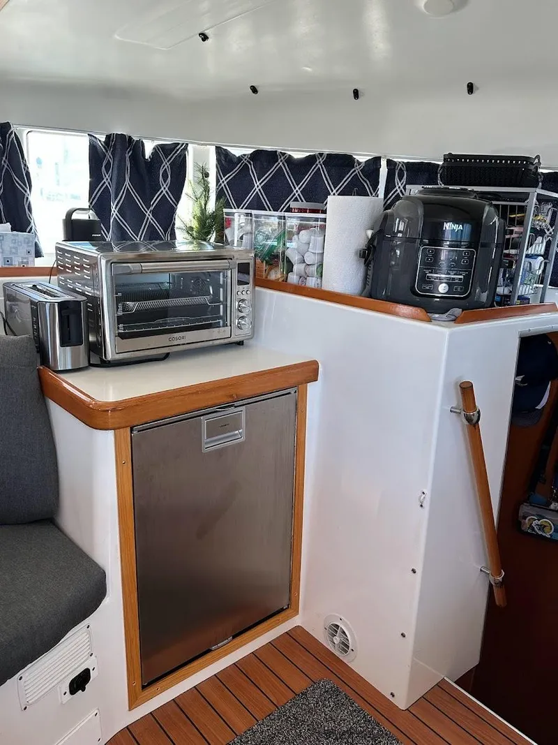 Slide: The Image of Interior of 2004 Lagoon 380 catamaran with modern kitchen appliances and wooden accents. - 9