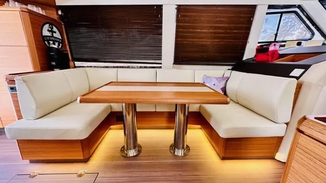 Slide: The Image of Luxurious interior of 2022 Greenline 48 Flybridge yacht with elegant seating and wooden table. - 11
