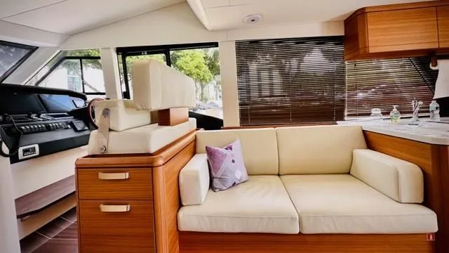 Slide: The Image of Interior of 2022 Greenline 48 Flybridge yacht with cream sofa and wooden accents. - 12