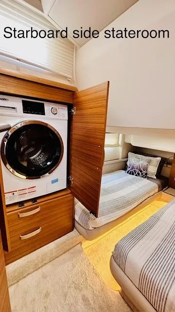 Slide: The Image of Starboard side stateroom with washer-dryer, twin beds, and modern decor on 2022 Greenline 48 Flybridge. - 19