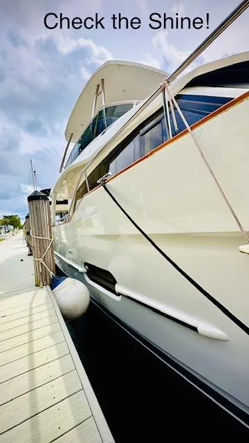 Slide: The Image of 2022 Greenline 48 Flybridge yacht with hardtop, docked, showcasing sleek, shiny exterior. - 2