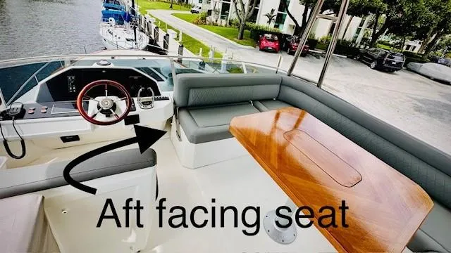 Slide: The Image of 2022 Greenline 48 Flybridge with Hardtop, featuring aft-facing seat and elegant wooden table. - 28