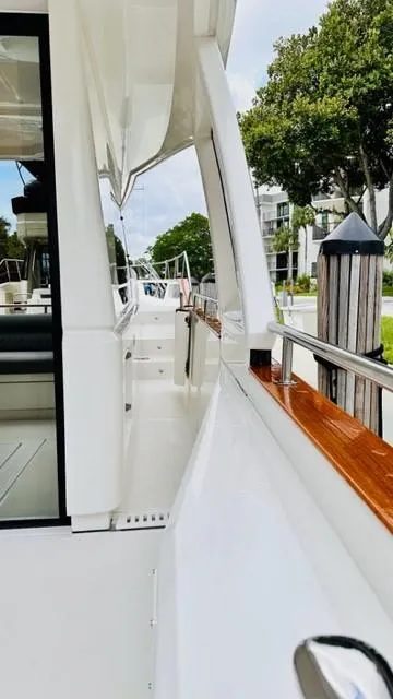 Slide: The Image of 2022 Greenline 48 Flybridge yacht with hardtop, docked, showcasing sleek design and polished wood accents. - 31