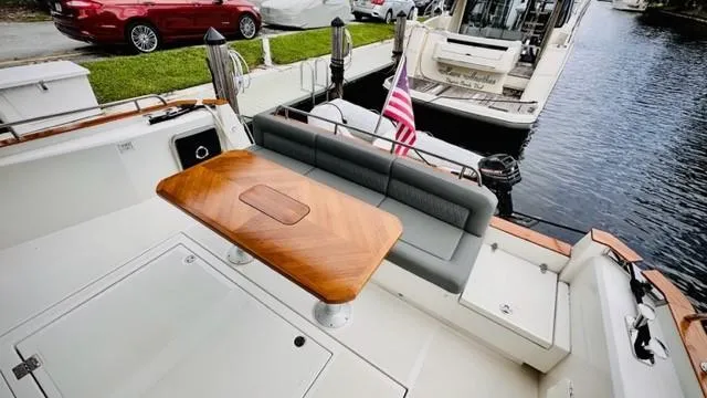 Slide: The Image of 2022 Greenline 48 Flybridge yacht with hardtop, featuring a sleek deck and elegant seating area. - 6