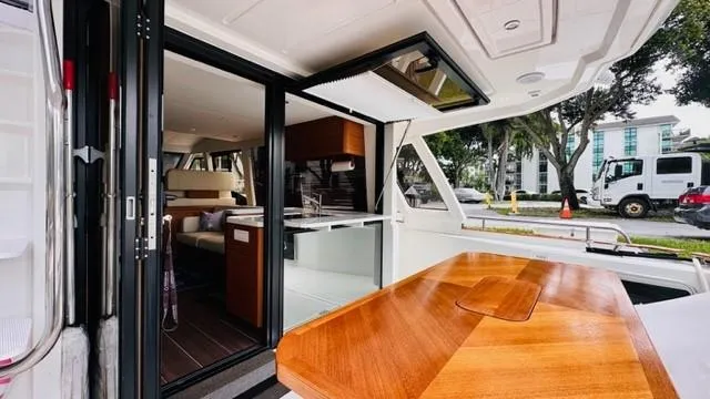 Slide: The Image of 2022 Greenline 48 Flybridge yacht interior with wooden table and modern kitchen. - 7
